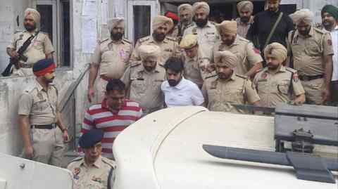 Lawrence Bishnoi, con camisa blanca, en medio de una fuerte seguridad policial mientras salía del complejo judicial de Amritsar el 31 de octubre de 2022 en Amritsar, India.