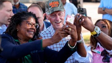 Bill Clinton, con una gorra con 'Harris Walz', se hace selfies con sus entusiastas seguidores sosteniendo teléfonos.