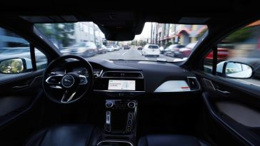 A Waymo autonomous self-driving Jaguar taxi drives along a street on March 14, 2024 in Los Angeles, California.