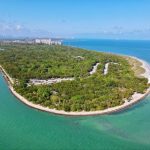 Una fotografía aérea de Key Biscayne, con el Parque Estatal Bill Baggs Cape Florida y su histórico faro en su extremo sur, y rodeado por el océano.