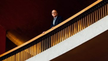 Peter Gelb, director general de la Met Opera, fotografiado mirando hacia abajo desde un balcón de la ópera