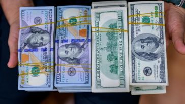 Hands holding US dollar bills at an exchange office at the Grand Bazaar in Istanbul