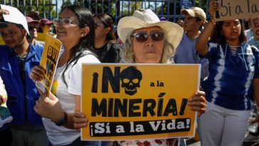 A woman holds up a sign in Spanish that translates to ‘No to mining, yes to life’, during a protest agains the mining bill San Salvador, El Salvador