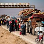 Los kurdos sirios, que huyen de sus hogares en las afueras de la ciudad norteña de Alepo después de ser capturados por rebeldes liderados por islamistas, llegan con sus pertenencias a Tabaqah, en las afueras occidentales de Raqa.