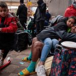 Venezuelan migrants as they wait for a ride-share at the 1st District police station in Chicago