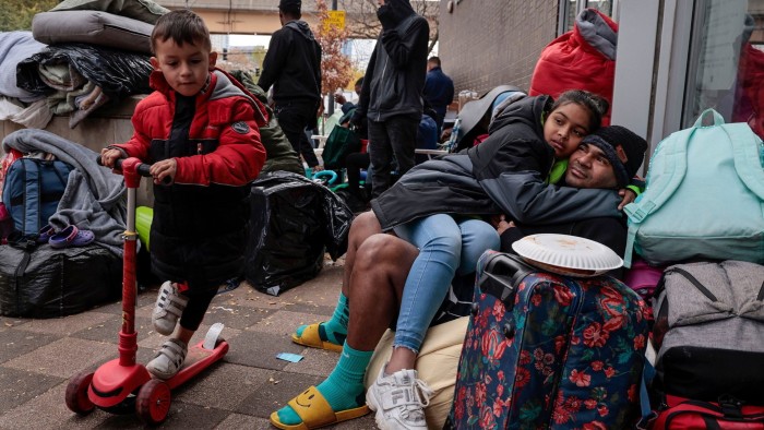 Venezuelan migrants as they wait for a ride-share at the 1st District police station in Chicago