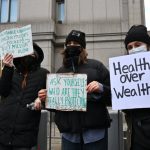 Los manifestantes sostienen carteles frente al tribunal federal de Manhattan, donde se espera que Mangione haga su aparición inicial el jueves.