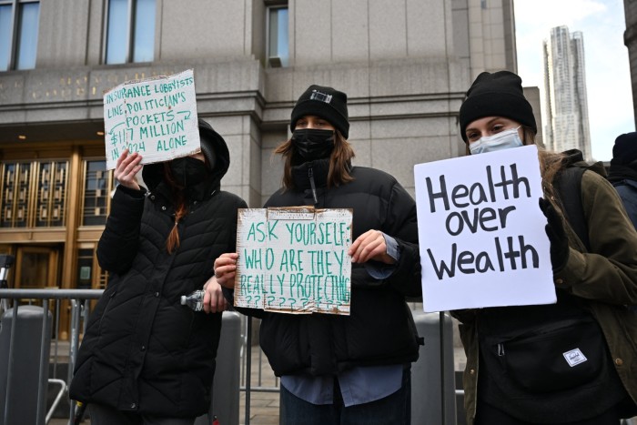 Los manifestantes sostienen carteles frente al tribunal federal de Manhattan, donde se espera que Mangione haga su aparición inicial el jueves.