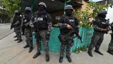 Policías hacen guardia durante un operativo para destruir viviendas que, según las autoridades, eran utilizadas por la banda criminal Chone Killer para tomar rehenes y asesinar a sus víctimas en Durán, Ecuador.