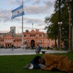 A homeless man sleeps at Plaza de Mayo square in front of Casa Rosada presidential palace in Buenos Aires