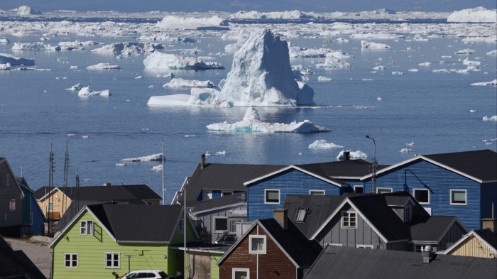 Icebergs seen from Greenland with houses in the foreground