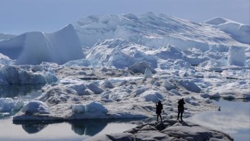 Visitantes observan el derretimiento de los icebergs en el fiordo helado de Ilulissat en julio de 2024 en Groenlandia