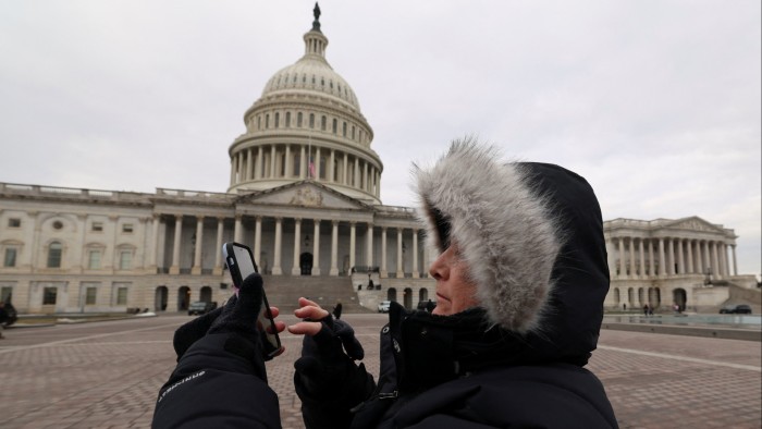 Person looks at her phone outside Capitol Hill