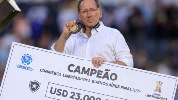 El propietario del Botafogo, John Textor, posa con el cheque del ganador después de la histórica victoria de su club en el estadio River Plate de Buenos Aires, Argentina.