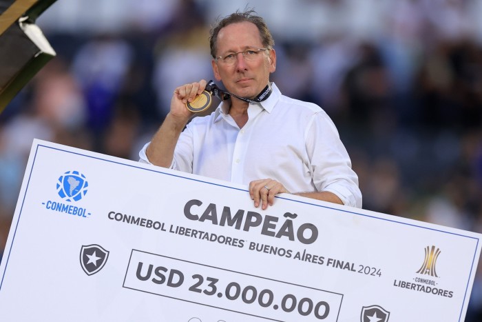 El propietario del Botafogo, John Textor, posa con el cheque del ganador después de la histórica victoria de su club en el estadio River Plate de Buenos Aires, Argentina.