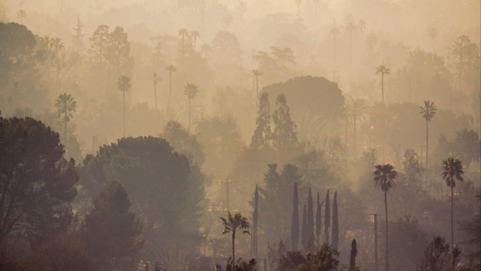 Smoke over destroyed homes in the aftermath of the Eaton Fire in Altadena, California