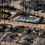 Una piscina se encuentra entre casas carbonizadas y automóviles quemados entre los escombros del Pacific Palisades Bowl Mobile Estates devastado por el fuego en Los Ángeles.