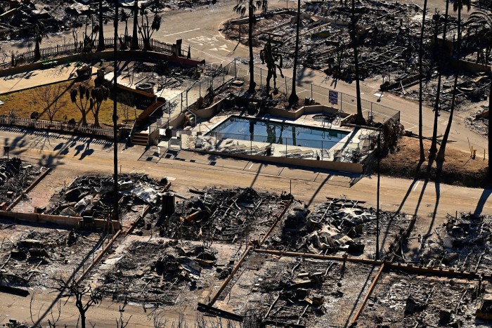 Una piscina se encuentra entre casas carbonizadas y automóviles quemados entre los escombros del Pacific Palisades Bowl Mobile Estates devastado por el fuego en Los Ángeles.