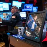 A picture of Donald Trump is displayed as traders work on the New York Stock Exchange